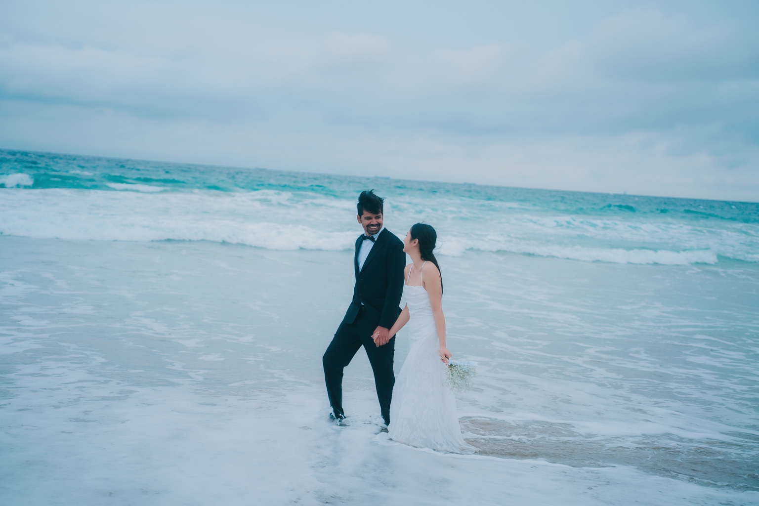 Vijay and Yati walking together on the beach